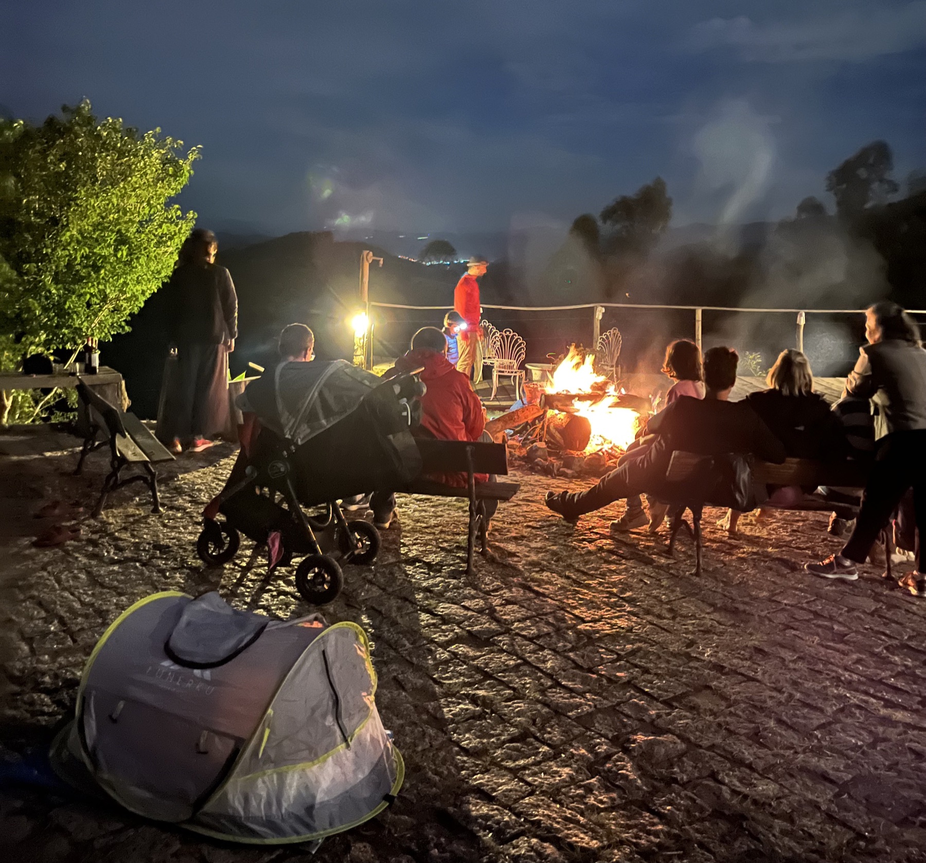 Grupo reunido ao redor da fogueira à noite no Instituto Alto Montana, durante um dos roteiros da Cria Outdoor