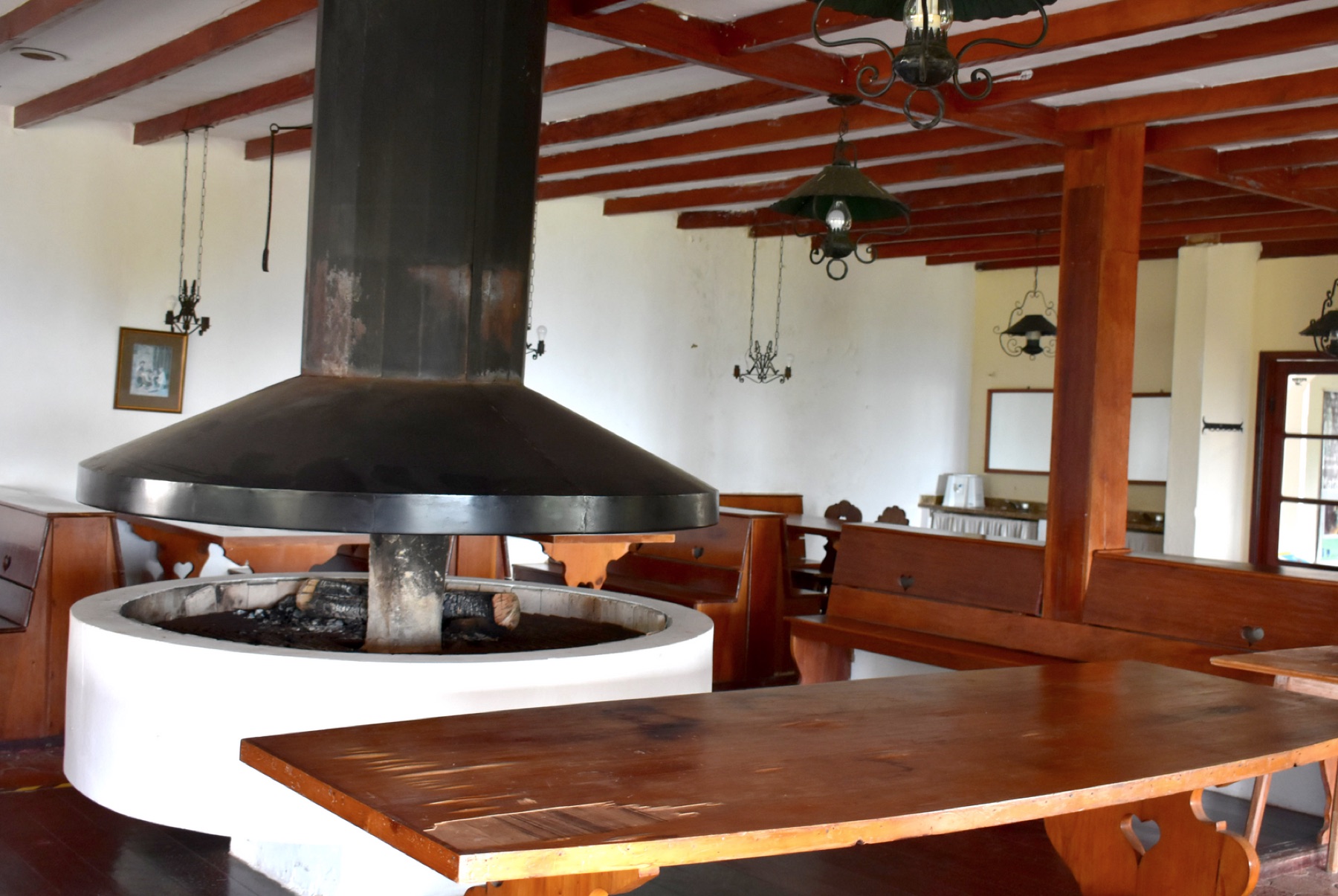 Sala de convivência com lareira central do Abrigo Alto Montana