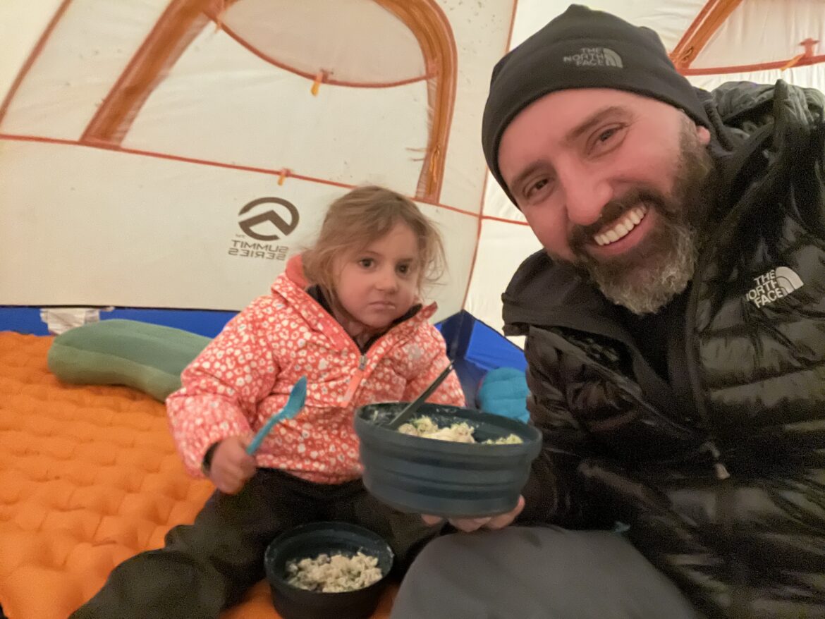 Hobby de pai: Fernando comendo pipoca com a filha dentro da barraca de acampamento